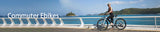 Blutron commuter ebike banner: A woman riding a Blutron e-bike along a sunlit coastal path lined with palm trees, showcasing this model as a best commuter ebike perfect for daily travels.
