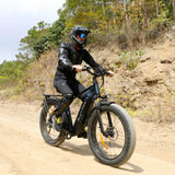 Rider in full protective gear navigates a dirt trail on a black Blutron fat tire ebike—this model features reliable fat tire ebike suspension, wide all-terrain tires, and a sturdy frame for smooth off-road performance.