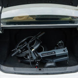 Blutron folding ebike 350w: Compact folded model stored in a car trunk, showcasing its space-saving design alongside visible tires and wiring components